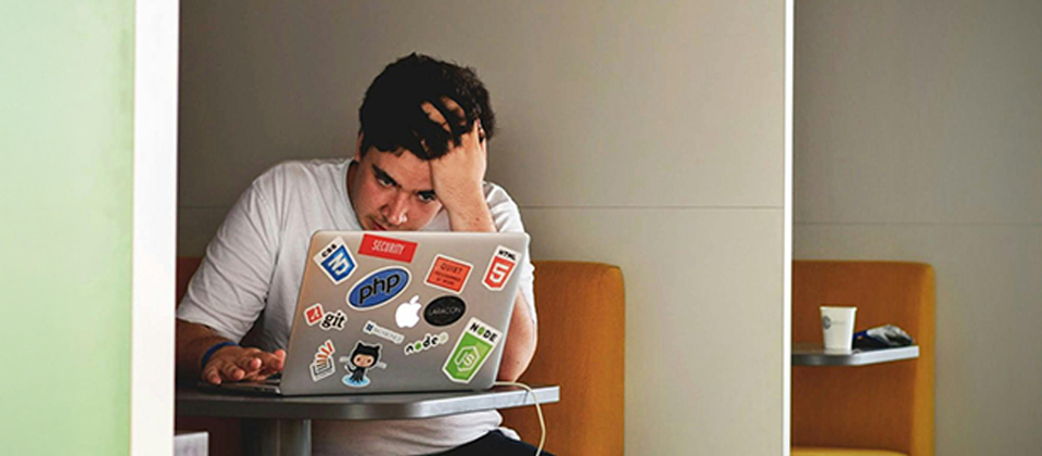 An engineer looks frustrated in a cubicle to illustrate the challenge of dealing with technical debt